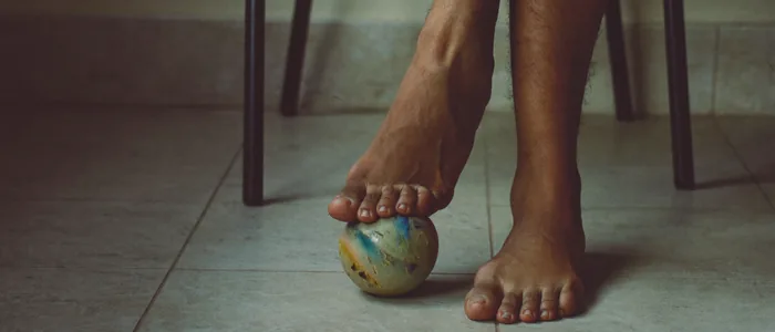 Rolling the arch of the foot over a small ball for relief