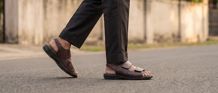 A man walking outdoors in AJM 12 brown orthopedic strap sandals