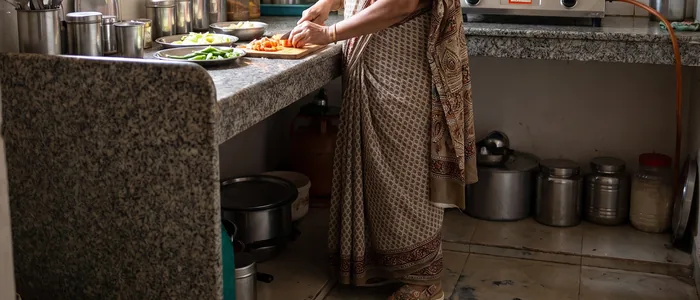 An older woman cooking at home wearing AJL 32 diabetic sandals