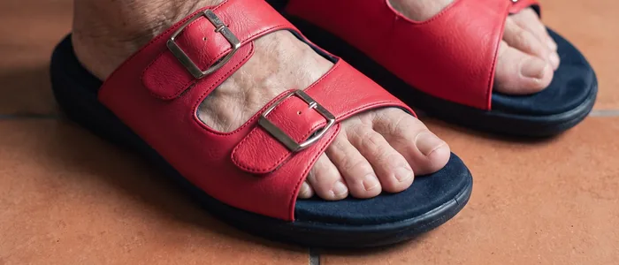 Feet in AJM 18 red buckle diabetic sandals on a home floor